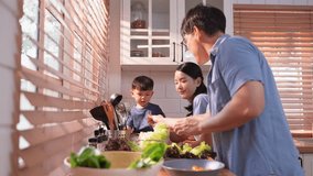 Happy Asian parents enjoying mealtime with their toddler in the kitchen, sharing laughter and playful moments during feeding time - Powered by Shutterstock - Get 15% off with code: PIKWIZARD15
