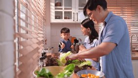 Happy Asian parents enjoying mealtime with their toddler in the kitchen, sharing laughter and playful moments during feeding time - Powered by Shutterstock - Get 15% off with code: PIKWIZARD15