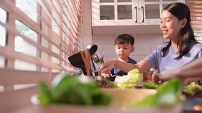 Happy Asian parents enjoying mealtime with their toddler in the kitchen, sharing laughter and playful moments during feeding time - Powered by Shutterstock - Get 15% off with code: PIKWIZARD15