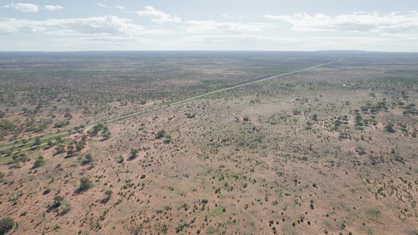 Isolated Road On Barren Deserts Near Uluru In Northern Territory, Australia. Aerial Drone Shot