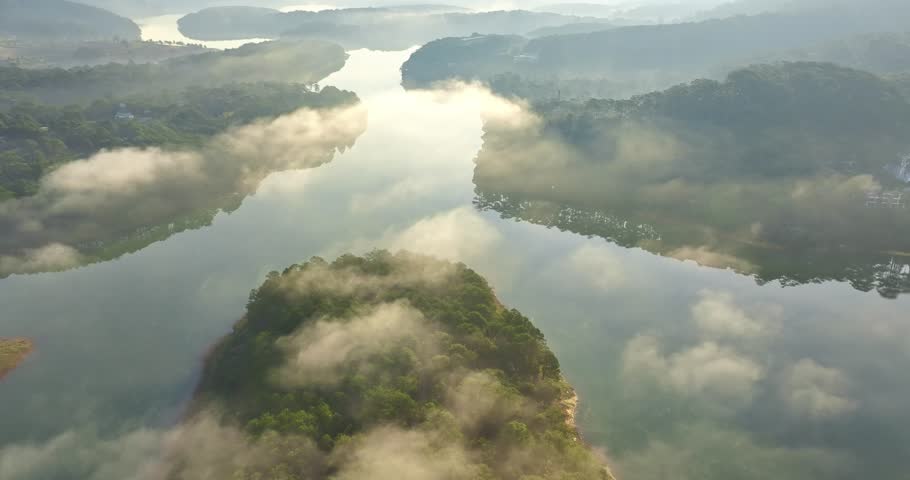 The morning sun rises in the Tuyen Lam lake of ​​Da Lat, Vietnam. The sun shines through the pine hills onto the quiet lake surface, it is wonderful to relax and watch the morning sunrise here.