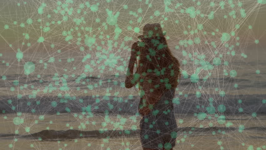 Female photographer adjusting sunhat lifting camera, snapping glowing sunset with tech overlay. Seascape, sunset, landscape, digital, glamour, tranquility, wanderlust