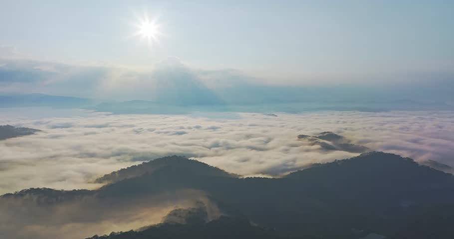 Aerial view of sunrise over the clouds with overlapping mountain ranges in Dalat, Vietnam
