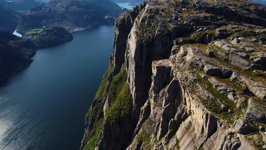 Majestic view of Preikestolen Pulpit Rock, Norway. Surrounded by fjord water and mountain terrain.