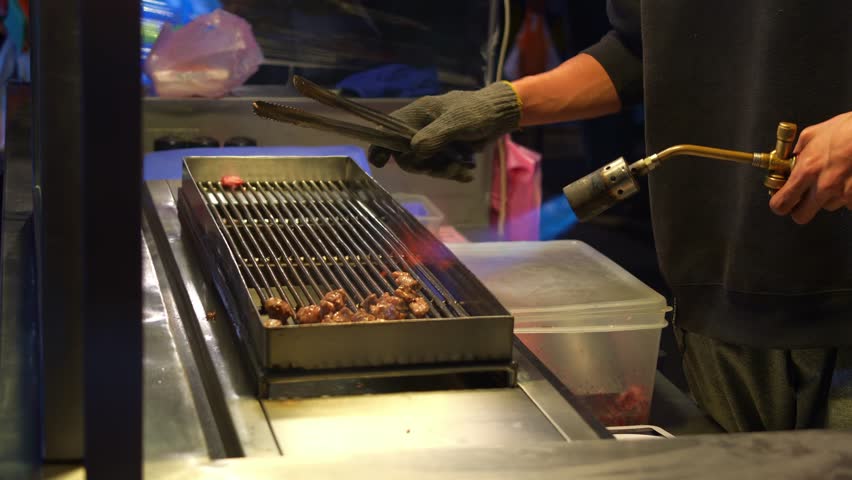 Juicy diced beef sizzles on the grill, the street vendor expertly tosses it with tongs, searing it with a culinary torch to get that perfect char.
