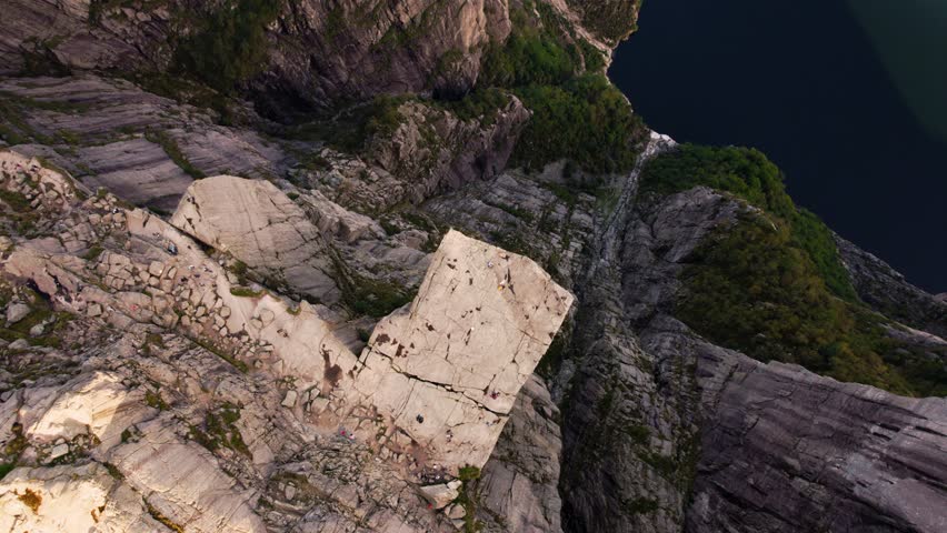 Top down drone footage of iconic Preikestolen Pulpit Rock in Norway. Hikers on the scenic cliff