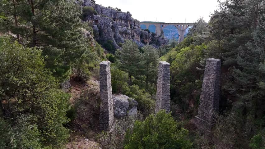 Drone Footage of Ruined Fortress Walls in a Forested Area  
