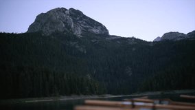 Wooden rowboats gently swaying, moored at serene black lake, surrounded by mountain forests in durmitor national park, montenegro - Powered by Shutterstock - Get 15% off with code: PIKWIZARD15