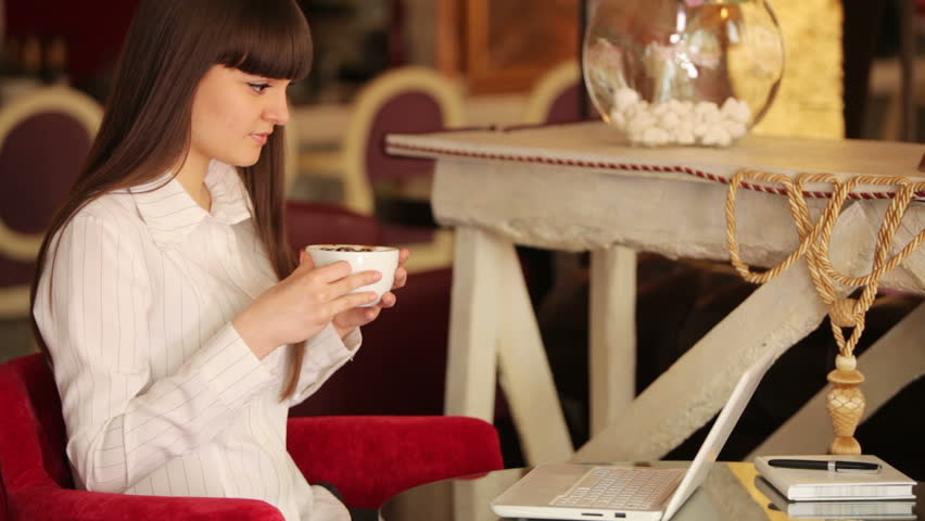 Businesswoman sitting in cafe and drinking coffee
