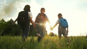 Happy family concept.group of children with backpacks run together on the green grass at sunset.picnic in nature.children go to school. active games in fresh air with backpacks.children rush to school - Powered by Shutterstock - Get 15% off with code: PIKWIZARD15
