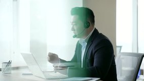 Silhouette. Asian businessman in headset talking on video call using laptop sitting in glass business office. Operator working in customer support service on helpline telesale. Call center. Side view - Powered by Shutterstock - Get 15% off with code: PIKWIZARD15