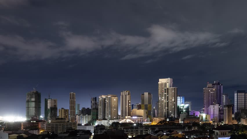 Time lapse of the clouds moving above the buildings in Manila, Philippines.