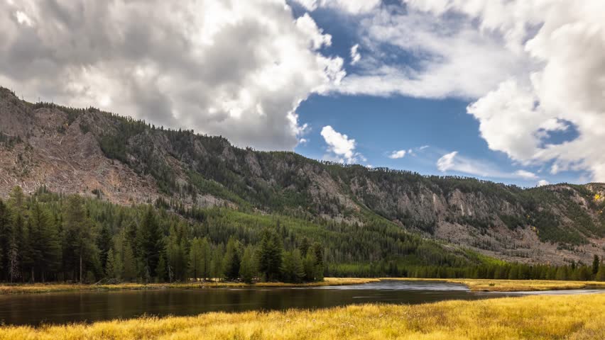 Time lapse of the clouds moving over the landscape of Yellowstone National Park in Wyoming. Madison River in the foreground.