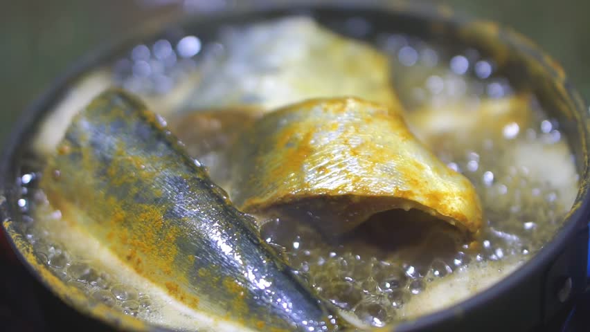 Kacang-Kacang Fish, in Latin Sphyraena putnamae is fried in a pan using a portable gas stove.