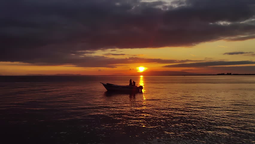 Human Silhouette on Boat in the Sea at Red Sunset Footage.