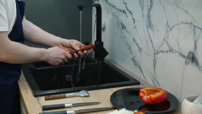 In a modern kitchen, a skilled chef meticulously prepares fresh ingredients, washing them under running water for cleanliness and food safety, laying the groundwork for a delicious meal - Powered by Shutterstock - Get 15% off with code: PIKWIZARD15