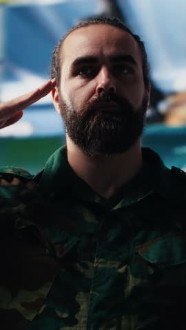 Vertical Video Veteran does military salute after reviewing satellite data in a control center, working on war planning tactics with battlefield details. High tech army environment for national safety