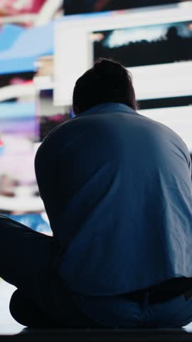 Vertical Video Desperate guy staring at phone screen in misery symbolizing toxic social media overuse. Obsession and excessive information affecting the mental health, anxiety and depression. Camera A