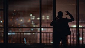 Angry man silhouette calling cellphone at dark office window workspace. Nervous businessman yelling smartphone having business problems at late cabinet. Furious man boss mobile phone talk at night - Powered by Shutterstock - Get 15% off with code: PIKWIZARD15