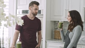 Couple enjoys green smoothies while chatting in their modern kitchen - Powered by Shutterstock - Get 15% off with code: PIKWIZARD15