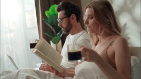 Family calm Caucasian couple drinking coffee in bed bedroom morning relationship wife read book literature pair relaxing bedding man using laptop husband woman drink energizing beverage weekend rest - Powered by Shutterstock - Get 15% off with code: PIKWIZARD15