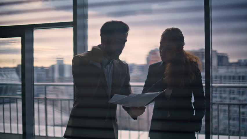 Angry director arguing secretary at big window room closeup. Stressed businessman holding papers gesturing aggressively. Upset nervous businesswoman throwing reports conflicting with business partner