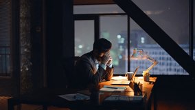 Calling executive working night cabinet closeup. Nervous worried man manager talking mobile phone at panoramic dark workplace. Stressed business consultant sitting office desk with laptop writing note - Powered by Shutterstock - Get 15% off with code: PIKWIZARD15