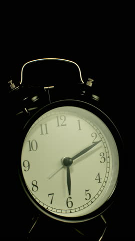 Vertical time lapse video of a clock time passing over a day to night on black background.