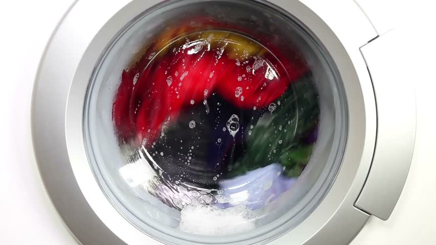 closeup working laundry machine spinning cleaning colorful cloth colored tumbling clothing soap