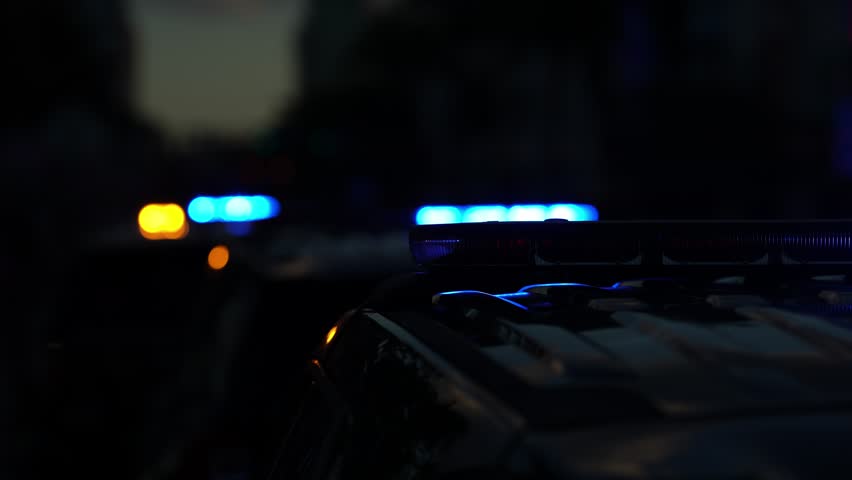 Police car flashing. Crime scene at night. Patrol vehicle outdoors. Emergency lights glowing. Flashing police siren. Police car vehicle. Law enforcement. City night patrol. Police arrest.