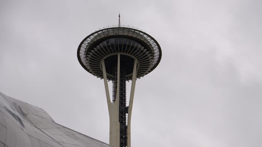 Daytime view of the iconic Space Needle in Seattle captured under a cloudy, overcast sky. 