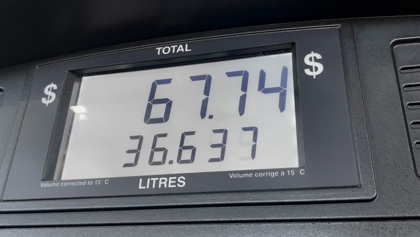 gas price screen in dollars on fuel pump increasing based on litres, close up