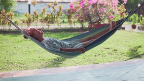 Woman is resting in hammock and enjoying summer in a garden. Afternoon relaxing. - Powered by Shutterstock - Get 15% off with code: PIKWIZARD15