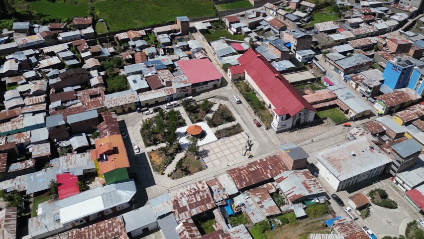 Aerial orbits quiet empty small town plaza, Cajatambo Peru mountains
