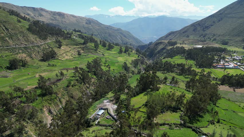 Flyover lush green agriculture mountain river valley at Cajatambo Peru