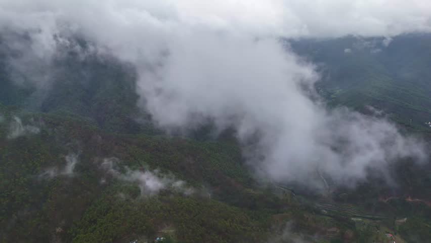 Aerial drone shot of a vibrant morning sky over mist-shrouded mountain forests.