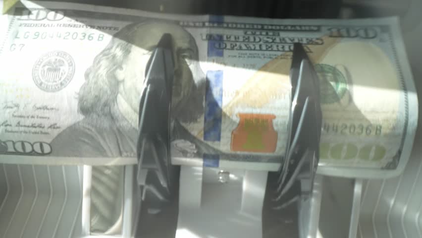 Close up cash counting machine counting money. Banknotes of 100 dollar bills. Money count machine, investment banking, cash transaction concept. Finance, currency and crisis recession.
