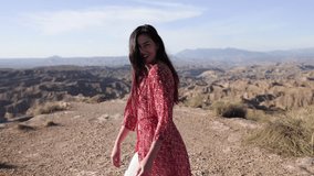 Female model wandering through expansive desert landscape, red hair blowing in warm sunlight while wearing flowing dress against scenic rocky terrain - Powered by Shutterstock - Get 15% off with code: PIKWIZARD15