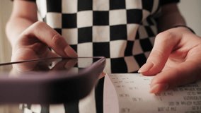 Woman using smartphone to calculate bill after shopping at the supermarket. Close up of hands checking grocery receipt, using a budgeting and money saving mobile apps. - Powered by Shutterstock - Get 15% off with code: PIKWIZARD15