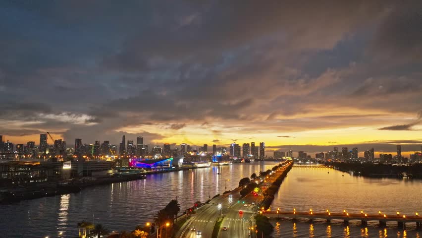 Miami Beach, South at night with dramatic sky. Miami Beach seaside at dusk. Aerial view of evening Miami Beach and cityscape. Coastline of Miami Beach night shot from the air drone.
