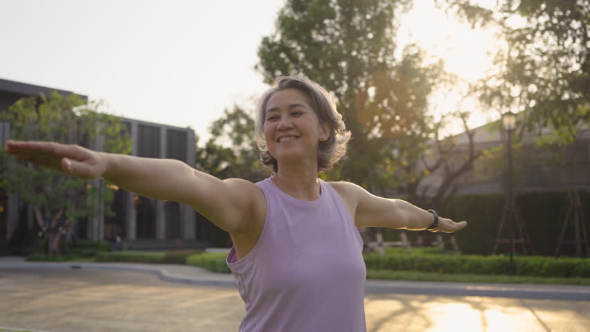 Asia adult aged people middle age mindful happy old woman yoga body pose zen calm stress relief outdoor nature public park sun light self love relax elder aging life asian female mental health care.