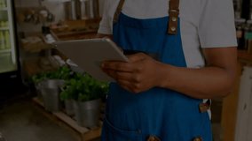 Store associate tapping tablet screen and creating floating green binary code visualizing shop data. Technology, analytics, digital, retail, innovation, data, workspace - Powered by Shutterstock - Get 15% off with code: PIKWIZARD15