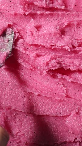 Vertical Screen: Texture of pink strawberry scrub. Fruit exfoliation scrubber for body and face in SPA. Body care scrub background for design.