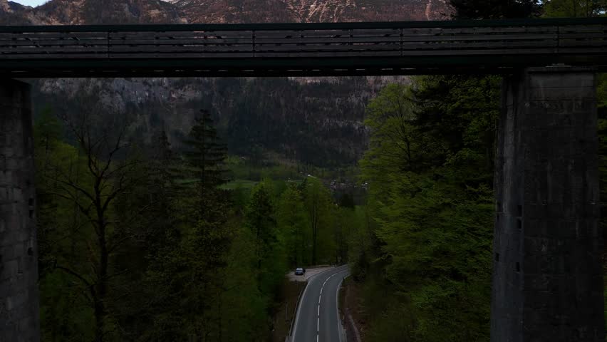 Aerial drone footage of the majestic Alpine mountains. Snow-capped peaks, lush valleys, and breathtaking natural scenery under a clear sky.

