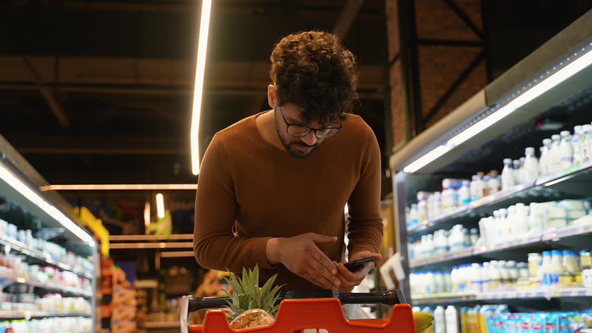 Arab man checking purchased groceries on smartphone