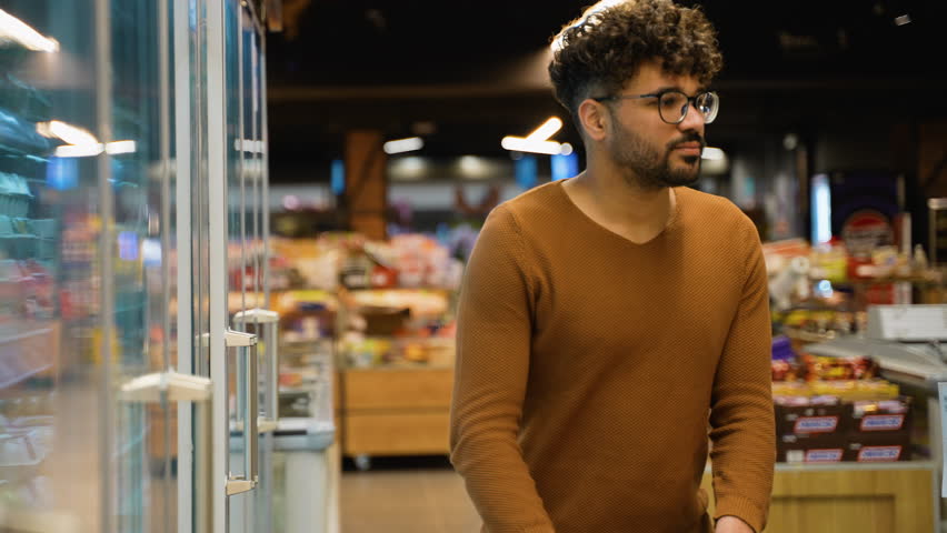 Arab man selecting chicken eggs in grocery store