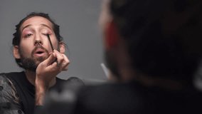 Cute gay queer man with beard applying eye make up - Real gender fluid person - Powered by Shutterstock - Get 15% off with code: PIKWIZARD15