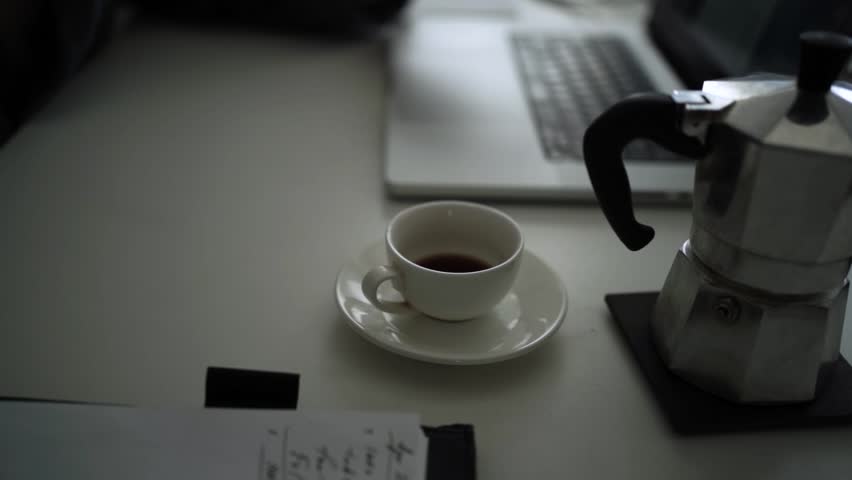 Office Desk Scene with Coffee Pouring from Moka Pot into White Cup