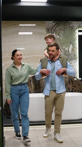 Family choosing bathroom fixtures in showroom with consultant