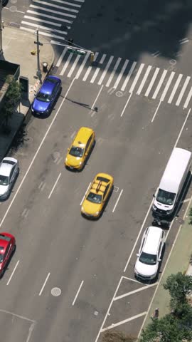 Top-down view of a busy Manhattan street filled with taxis, cars, and pedestrians. A classic New York City traffic scene capturing the fast-paced urban life from above.	